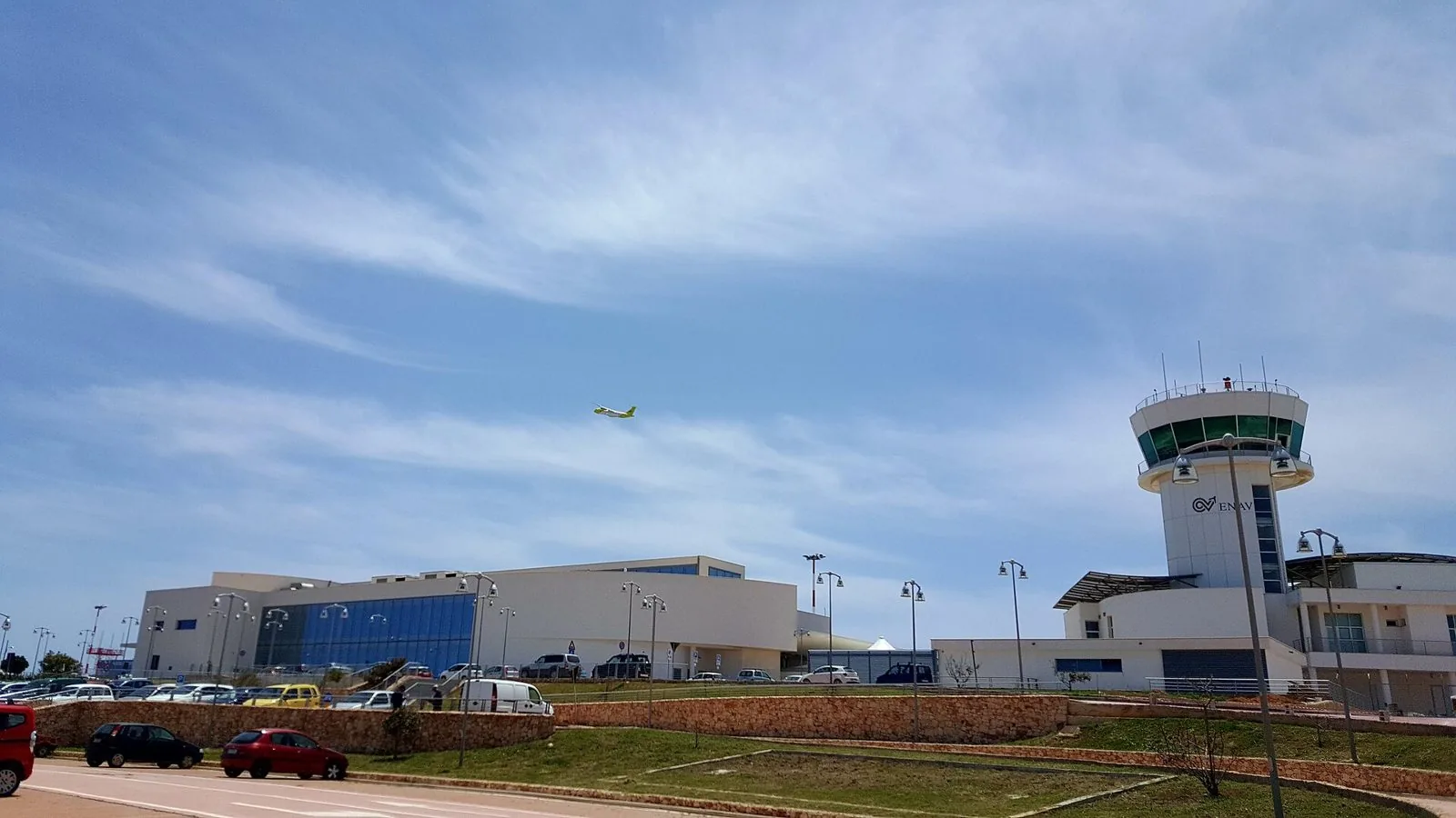 Il terminal e la torre di controllo dell'aeroporto di Lampedusa con un aereo in decollo